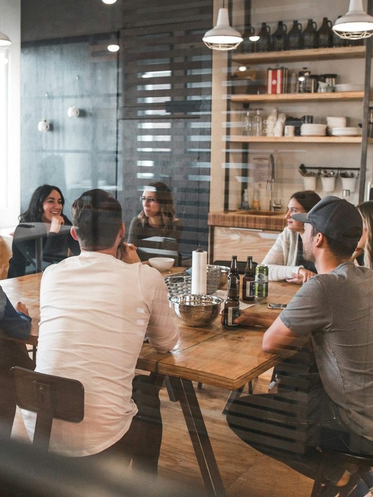 Reunión de personas alrededor de una mesa en un ambiente moderno y acogedor. Reunión de personas alrededor de una mesa en un ambiente moderno y acogedor.